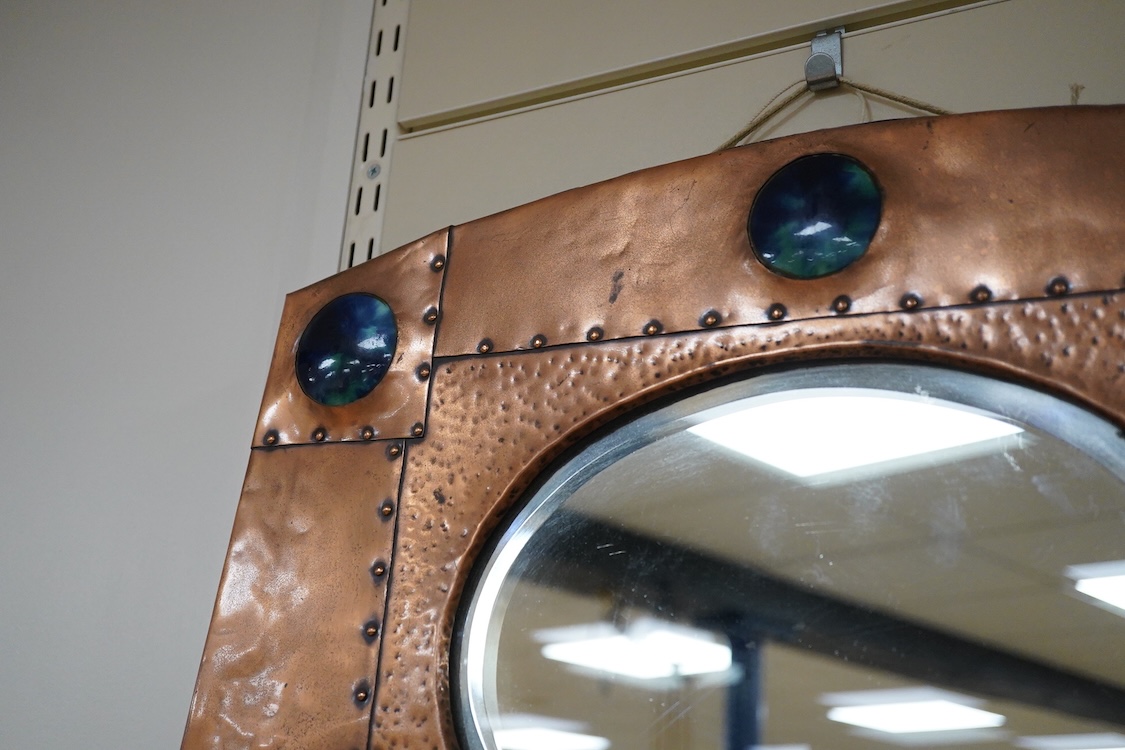 An Arts and Crafts riveted copper and Ruskin pottery cabochon inset mirror, 39cm high